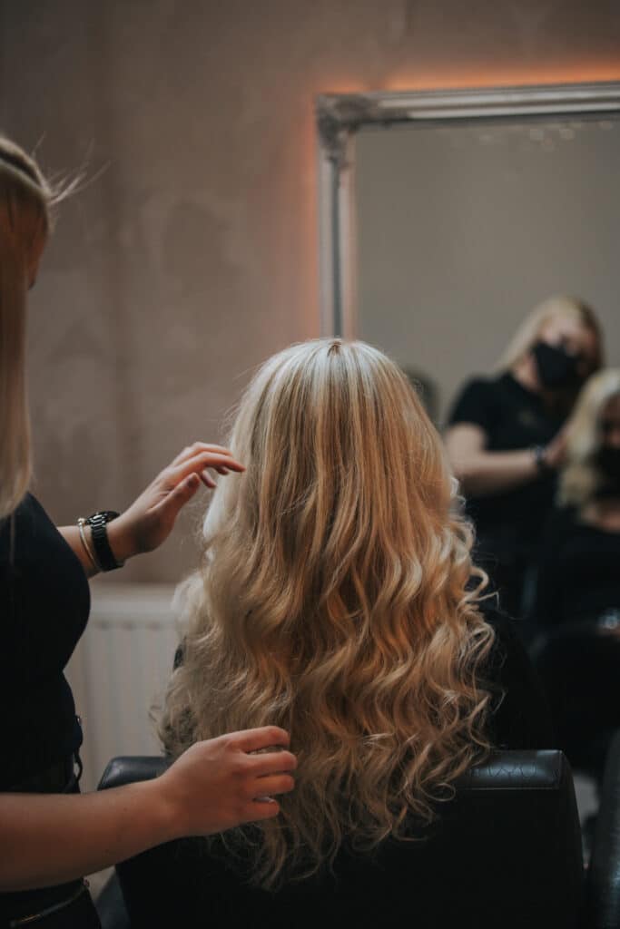 mujer en peluquería recibiendo tratamiento de color